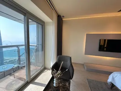 a room with a bedroom with a view of the ocean at Skyline Sanctuary on the 82nd in Dubai