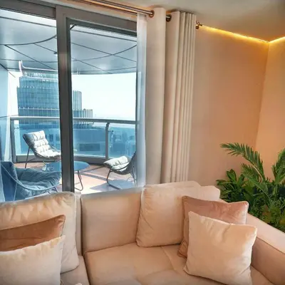 a living room with a couch and a balcony at Skyline Sanctuary on the 82nd in Dubai