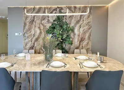 a dining room table with a vase of flowers on it at Skyline Sanctuary on the 82nd in Dubai