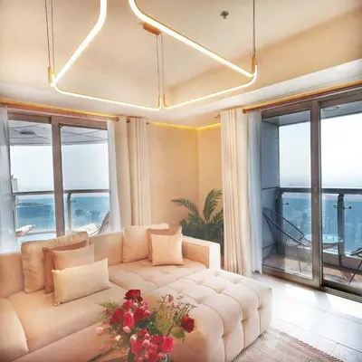 a living room with a large couch and windows at Skyline Sanctuary on the 82nd in Dubai