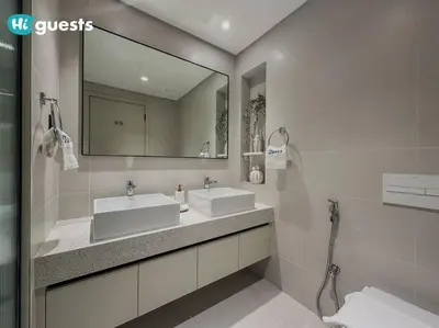 a bathroom with two sinks and a large mirror at HiGuests - Elegant 2-Bedroom Retreat at Marina Vista 2 in Dubai