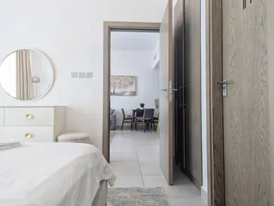 a bedroom with a bed and a mirror and a table at Fully Furnished 1BR Close by Dubai Science Park, Dubai Miracle Garden, Dubai Hills Mall in Dubai