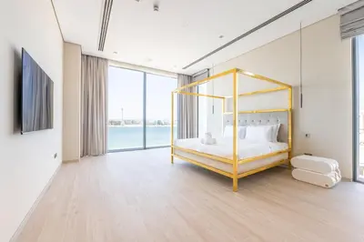 a bedroom with a bed with a gold frame at Ultra-Luxury 6BR Palm Villa - Private Pool & Beach in Dubai