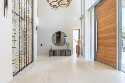 a hallway with a wooden door and a mirror at Ultra-Luxury 6BR Palm Villa - Private Pool & Beach in Dubai