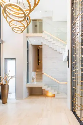 a staircase in a house with a chandelier at Ultra-Luxury 6BR Palm Villa - Private Pool & Beach in Dubai