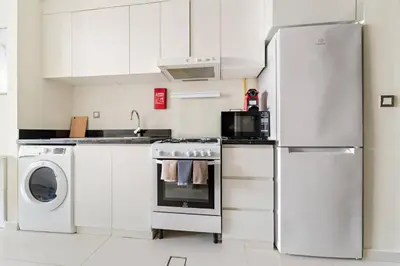 a kitchen with a refrigerator and a washer and dryer at FIRST CLASS Studio Luxury Getaway in Dubai