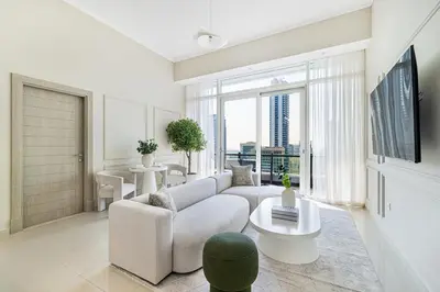 a living room with a white couch and a large window at Daniels Stylish 1BR at Silverene Tower Dubai Marina in Dubai