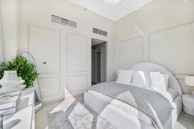 a white bedroom with a bed and a mirror at Daniels Stylish 1BR at Silverene Tower Dubai Marina in Dubai