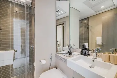 a bathroom with a sink and a toilet and a mirror at Daniels Stylish 1BR at Silverene Tower Dubai Marina in Dubai