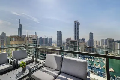a balcony with two chairs and a view of a city at Daniels Stylish 1BR at Silverene Tower Dubai Marina in Dubai