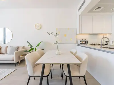 a kitchen and dining room with a table and chairs at Modern Spacious- 2 BR with Pool & Gym- Luma 22 JVC in Dubai
