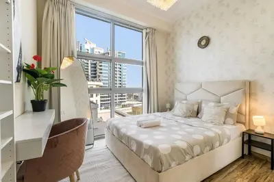 a bedroom with a bed and a desk and a window at Royal King Size Stay 2BR With Marina View in Dubai