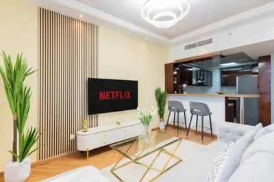 a living room with a tv on a wall at Luxury 3BR with Stunning Full Marina View in Dubai in Dubai
