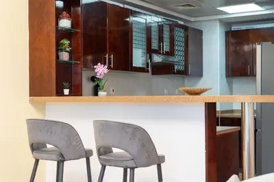 a kitchen with two chairs sitting at a counter at Luxury 3BR with Stunning Full Marina View in Dubai in Dubai