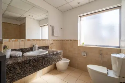 a bathroom with a sink and a toilet and a mirror at GuestReady - Serene retreat with Ain Dubai Views in Dubai