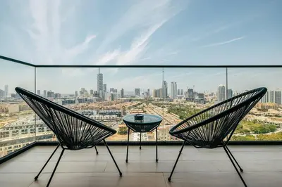 two chairs on a balcony with a view of a city at Beautiful 1BR - City View - Pool - Free Parking in Dubai
