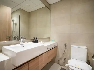 a bathroom with a white sink and a toilet at Elegant Studio in Azizi Riviera, Meydan in Dubai