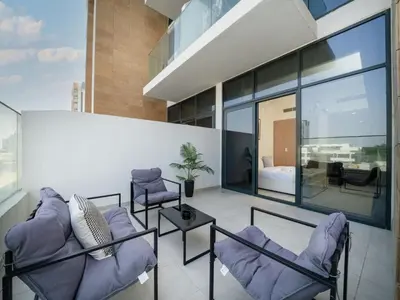 a living room with purple chairs and a bedroom at Elegant Studio in Azizi Riviera, Meydan in Dubai