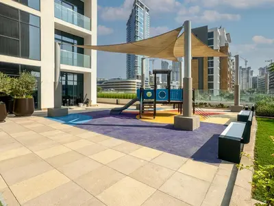 a playground in front of a building with a canopy at Elegant Studio in Azizi Riviera, Meydan in Dubai