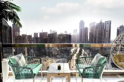 a balcony with chairs and a table and a view of a city at Lux apartments x Dubai studio 22 in Dubai