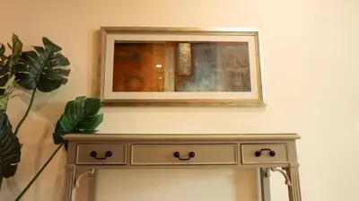 a dresser in a room with a mirror on the wall at Modern Apartment near Burj khalifa in Dubai