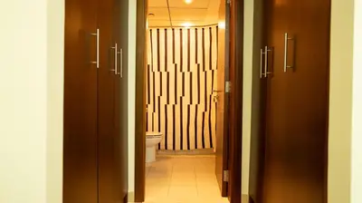 a bathroom with a toilet and a hallway with two doors at Modern Apartment near Burj khalifa in Dubai