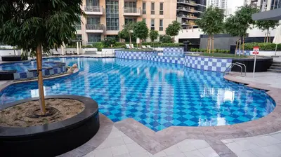 a large blue swimming pool in a city at Modern Apartment near Burj khalifa in Dubai