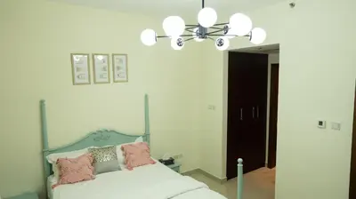 a bedroom with a bed and a chandelier at Modern Apartment near Burj khalifa in Dubai