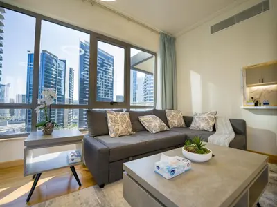 a living room with a couch and large windows at EasyGo- amazing 1bdr with view south ridge- downtown in Dubai