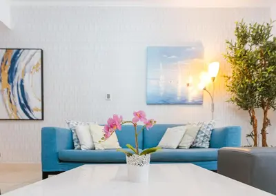 a living room with a blue couch and a table at Elegant 2BR Apartment in Yansoon 3 with Burj Khalifa Views in Dubai
