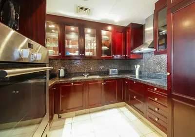 a kitchen with wooden cabinets and a stainless steel appliance at Elegant 2BR Apartment in Yansoon 3 with Burj Khalifa Views in Dubai