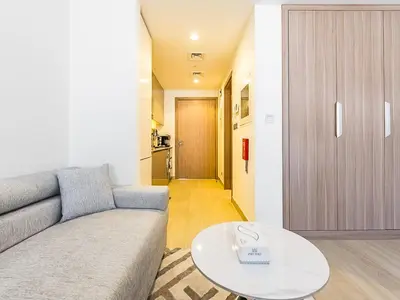 a living room with a couch and a table at Relaxing Studio Retreat in Vibrant Meydan City in Dubai