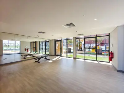 a large room with large windows and a gym at Relaxing Studio Retreat in Vibrant Meydan City in Dubai