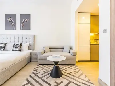 a living room with a couch and a table at Relaxing Studio Retreat in Vibrant Meydan City in Dubai