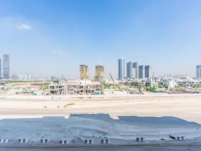 a view of a beach with a city in the background at Relaxing Studio Retreat in Vibrant Meydan City in Dubai