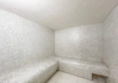 a bathroom with white tiled walls and a bench at Stunning Newly Furnished Apartment Dubai Marina in Dubai