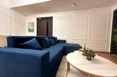 a living room with a blue couch and a table at Stunning Newly Furnished Apartment Dubai Marina in Dubai