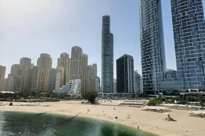 a beach in front of a city with tall buildings at Beachfront 250 view private beach high floor in Dubai