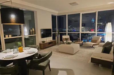 a living room with a table and chairs and a large window at Beachfront 250 view private beach high floor in Dubai
