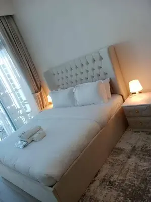a bed in a room with a large window at Stonetree - Studio Unit at Azizi Riviera 45 in Dubai