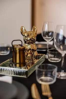 a gold dog statue on a table with wine glasses at Large 2BR with Marina and Sea View in 5242 Tower - EE Holiday Homes in Dubai