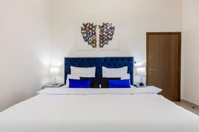 a bedroom with a large white bed with blue accents at Large 2BR with Marina and Sea View in 5242 Tower - EE Holiday Homes in Dubai