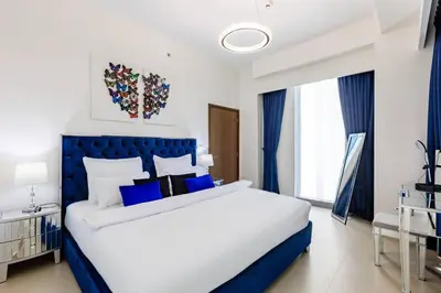 a white and blue bedroom with a large bed at Large 2BR with Marina and Sea View in 5242 Tower - EE Holiday Homes in Dubai