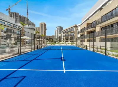 a tennis court in front of a building at Luxury Apartment in Oakley Square Residences, JVC in Dubai