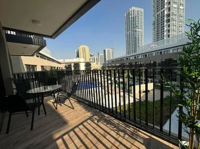 a balcony with a table and chairs and a view of a city at Luxury Apartment in Oakley Square Residences, JVC in Dubai