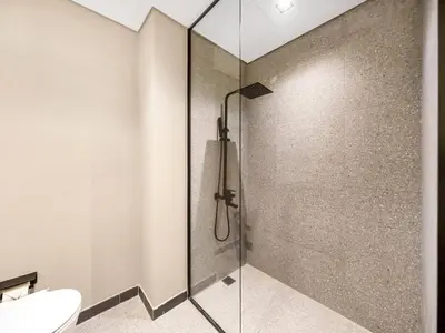 a bathroom with a glass shower with a toilet at Sukoon's Elegant Suite 2 in Dubai