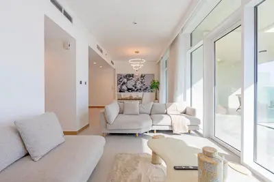 a living room with white furniture and large windows at Luxury 1 & 2 BHK Apartments, Branded & State of The Art Amenities in Dubai