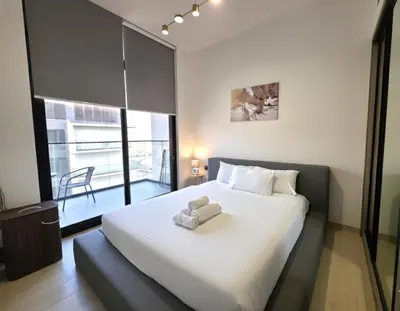 a bedroom with a large white bed and a large window at 1 Bed Retreat- RBE Vacation Homes-Binghatti Luna in Dubai
