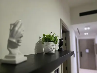 a plant in a white vase sitting on a counter at 1 Bed Retreat- RBE Vacation Homes-Binghatti Luna in Dubai