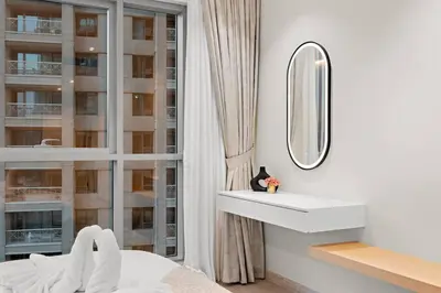 a bedroom with a bed and a mirror and a window at FIRST CLASS 2BR Incredible Burj Khalifa View in Dubai